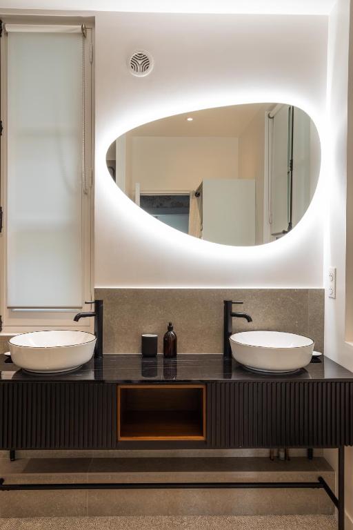 a bathroom with two sinks and a large mirror at Le Goya - Appartement 4 chambres centre ville de Rennes in Rennes