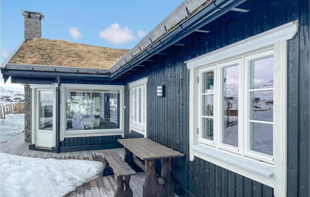una casa azul con un banco en una cubierta en Beautiful Home In Fl With Sauna en Flå