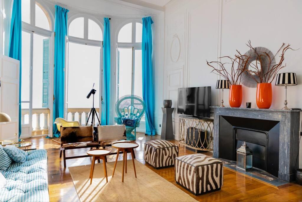 a living room with a fireplace and blue curtains at Monaco/Beausoleil I : Luxury Apartment 1BR vue Mer in Beausoleil