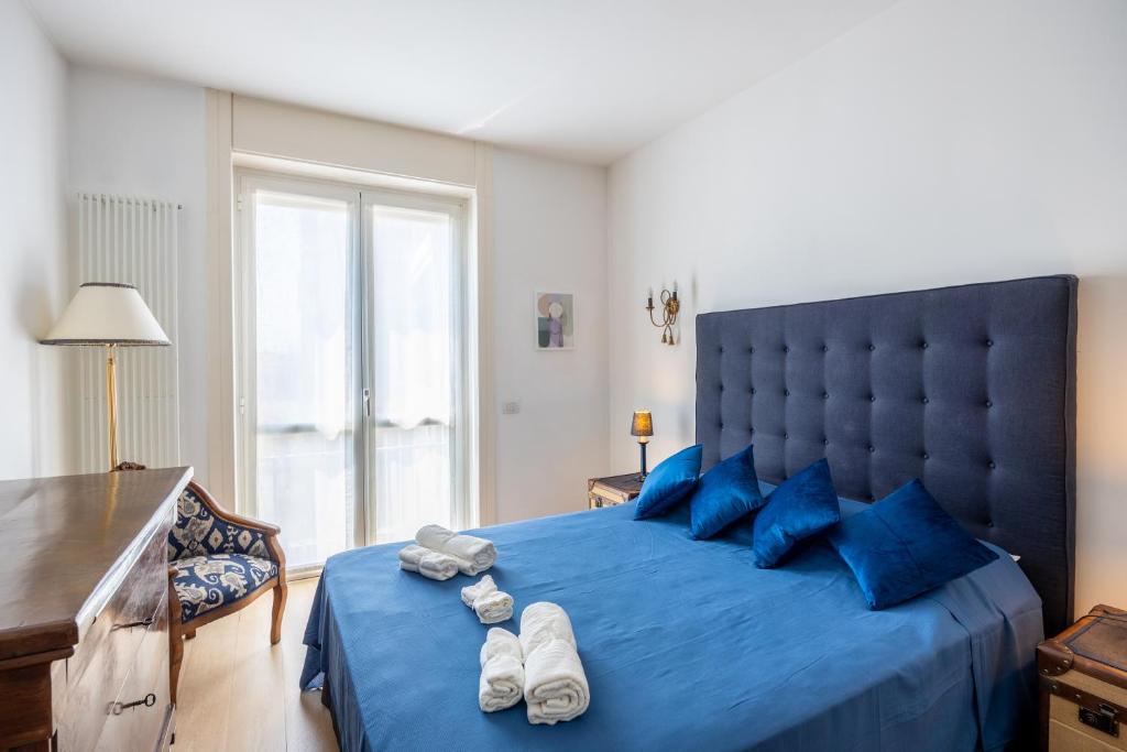 ein Schlafzimmer mit einem großen blauen Bett mit blauen Kissen in der Unterkunft [BOCCONI] Elegante Appartamento con WIFI in Mailand