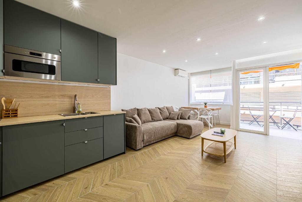 une cuisine et un salon avec un canapé et une table dans l'établissement Cozy renovated apartment - close to Martinez Hotel, à Cannes