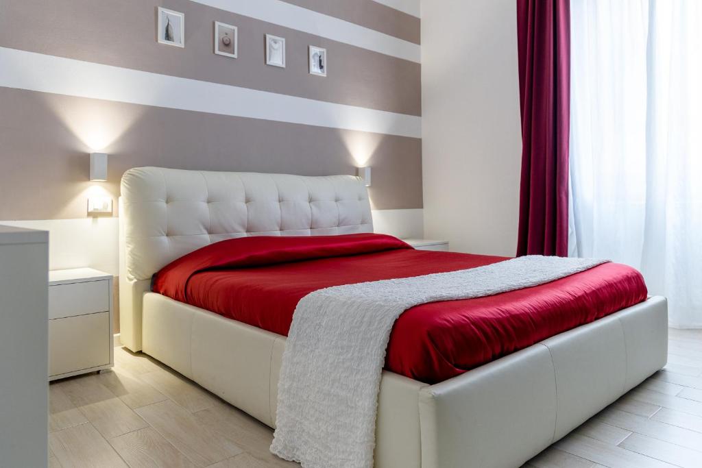 a bedroom with a white bed with a red blanket at Myro's House in La Spezia