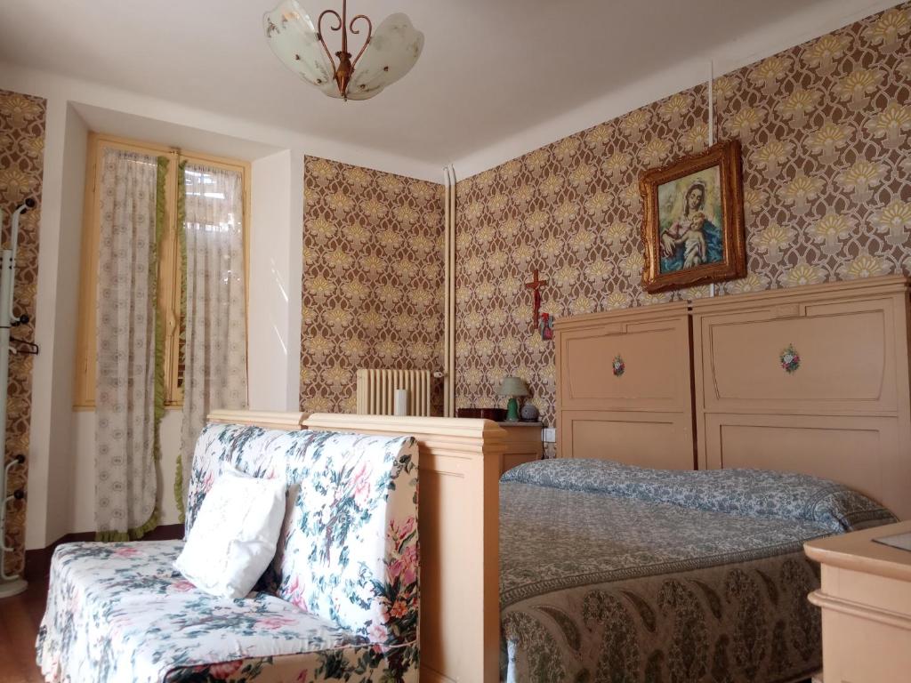 a bedroom with a bed and a chair at Villa Giulia in Lura