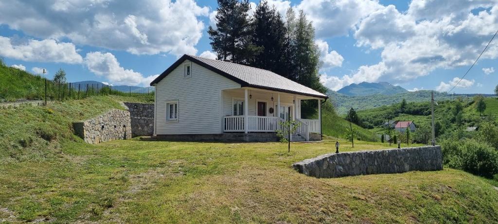 ein kleines weißes Haus auf einem Grashügel in der Unterkunft Snow White in Kolašin