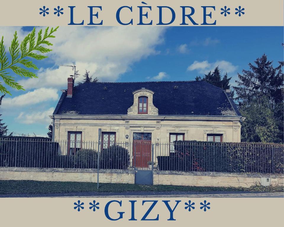 a white house with a red door and a fence at Le Cèdre 