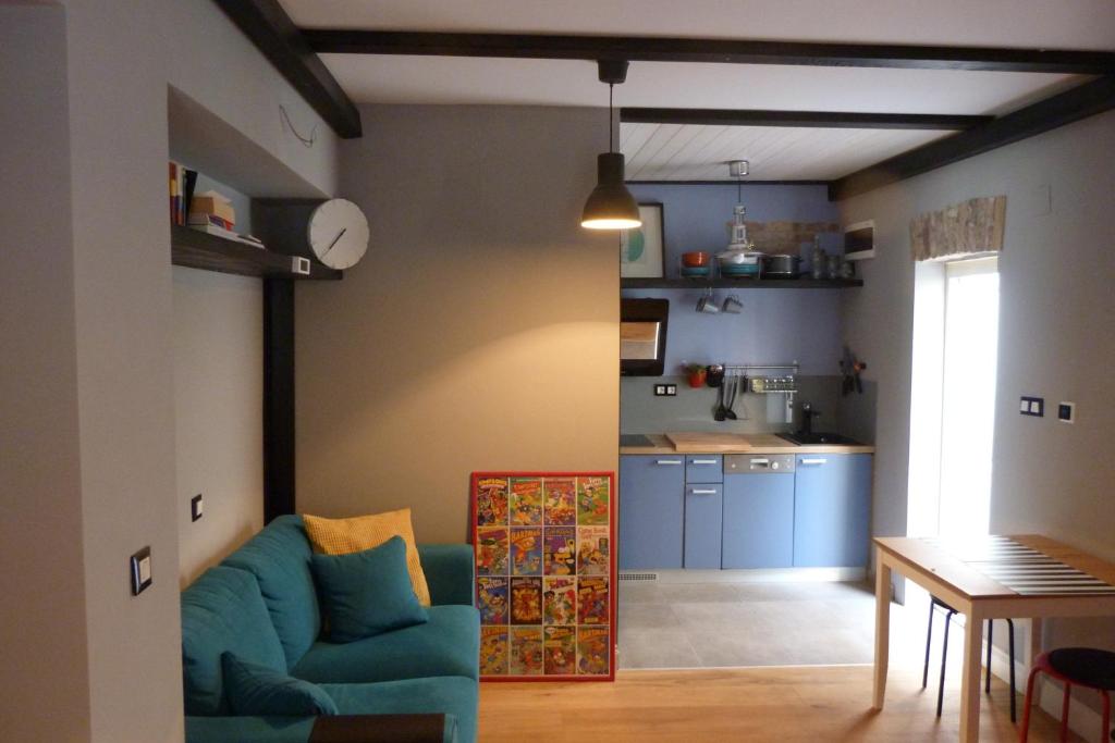 uma sala de estar com um sofá azul e uma cozinha em We Collect Umbrellas em Split