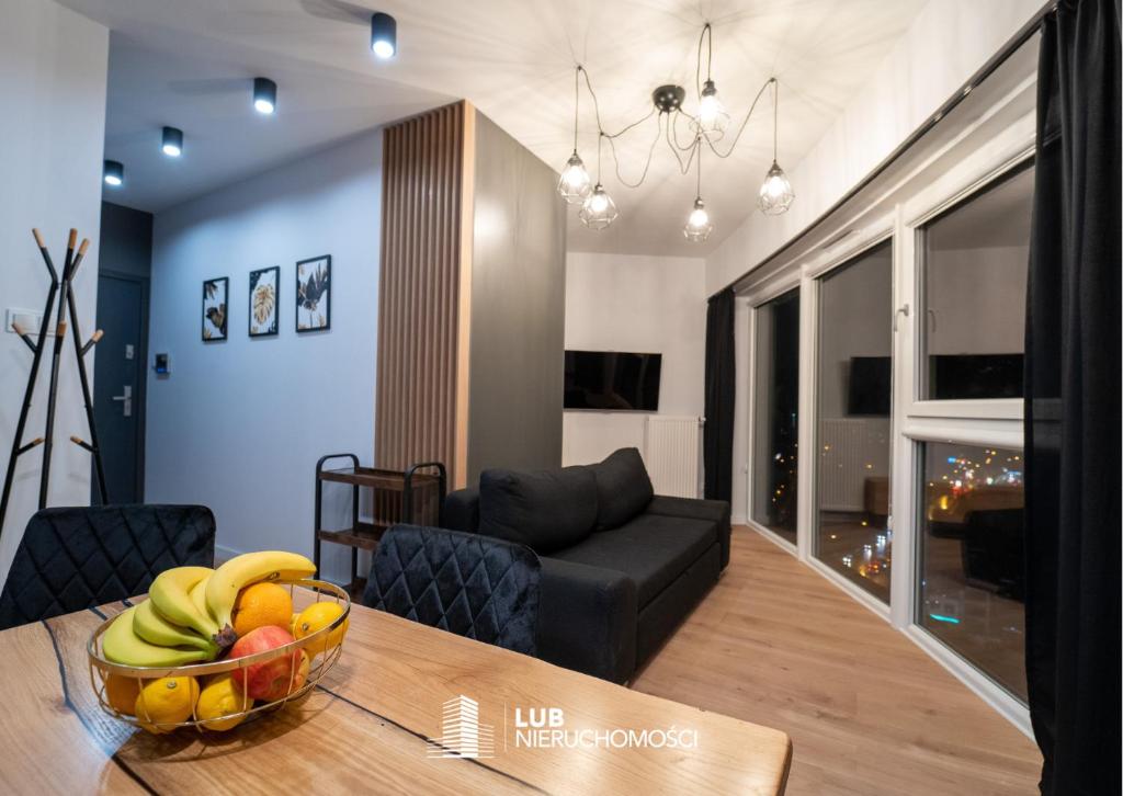 eine Schale mit Obst auf einem Tisch in einem Wohnzimmer in der Unterkunft Panorama Capital Tito - 16 piętro in Rzeszów