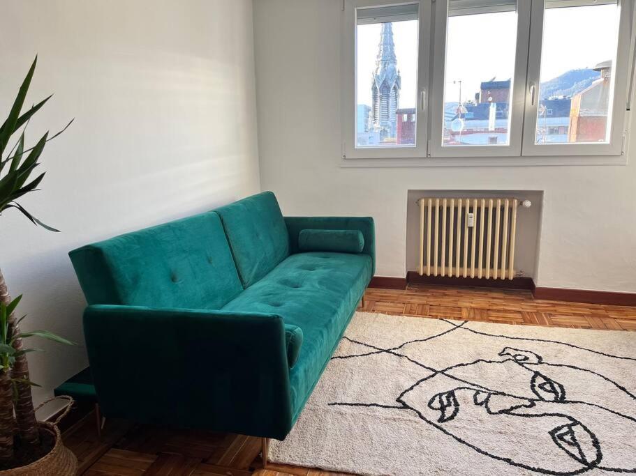 un soggiorno con divano verde e tappeto di Ático en el centro recién reformado a Oviedo