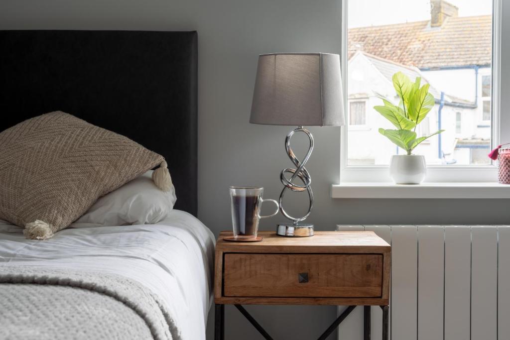 - une chambre avec un lit et une table avec une lampe dans l'établissement Gorgeous House with BBQ Patio, à Great Yarmouth