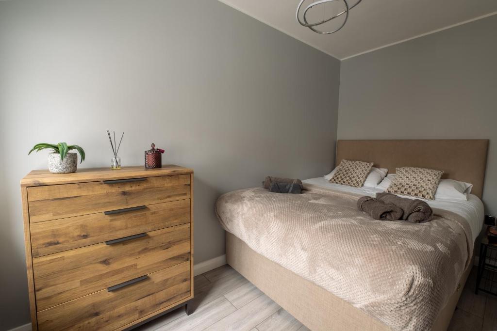a bedroom with a bed and a wooden dresser at Gorgeous House with BBQ Patio in Great Yarmouth