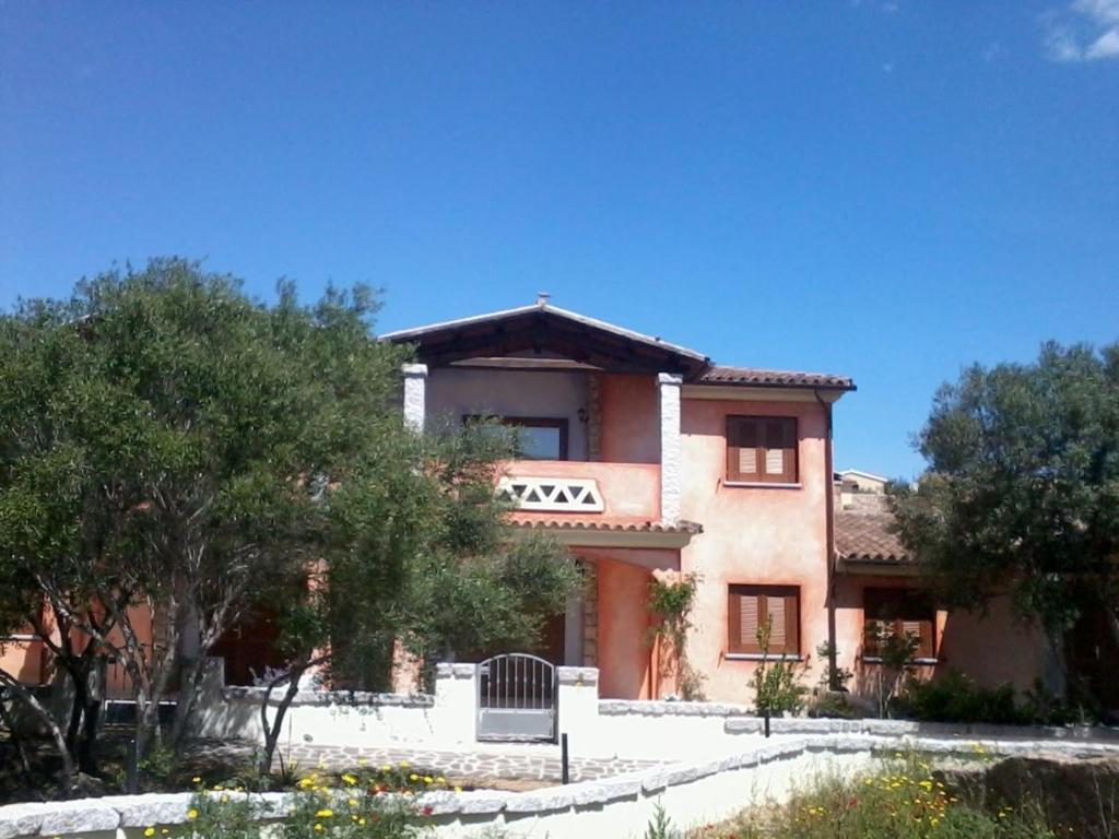 una grande casa con alberi di fronte di Li Rocchi a San Teodoro