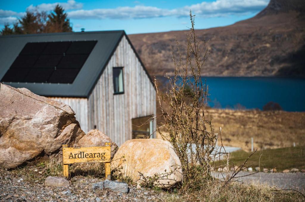 a sign in front of a barn with a solar roof at Stunning loch view home sleeping 8 in Garve