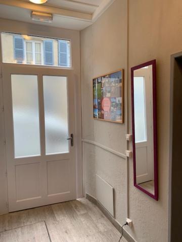 a room with a white door and a mirror at Appartement rez de chaussée Gold beach in Bayeux