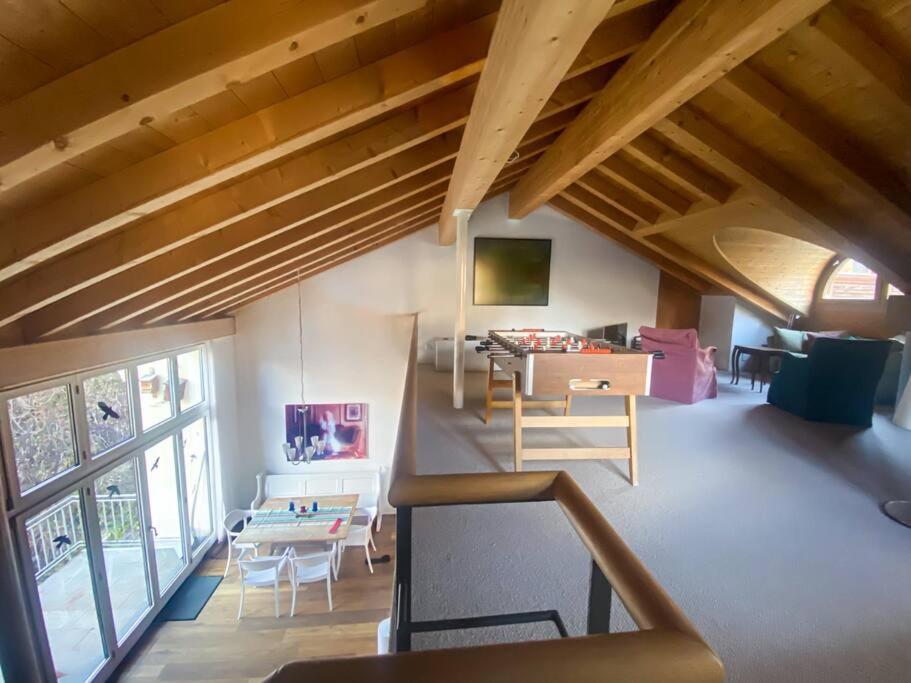een woonkamer met houten plafonds en een groot raam bij 4 1/2 Room Maisonette Apartment with great views in Sils Maria