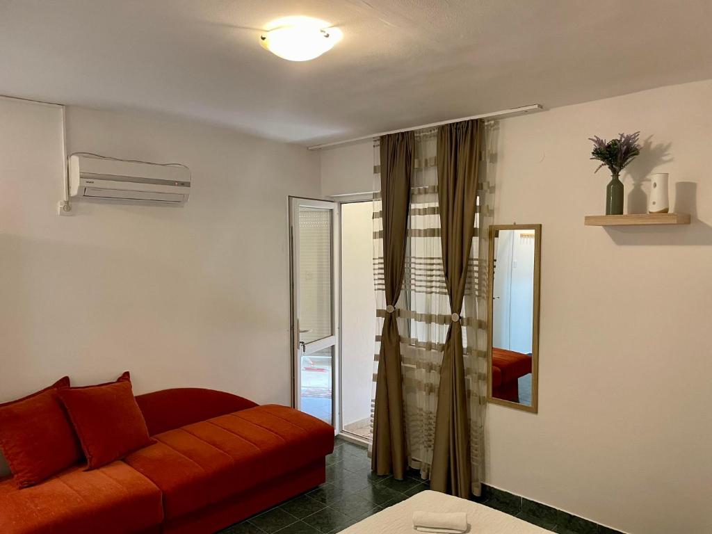 a living room with a red couch and a window at 4 Studios Becic in Budva