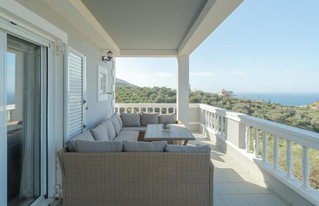 d'une terrasse avec un canapé et une table sur un balcon. dans l'établissement Carmine Olive Villa, à Agia Pelagia
