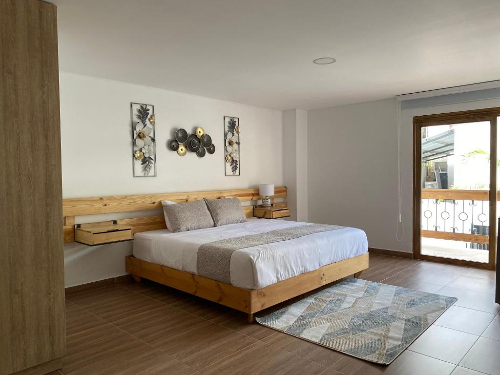 Hotel Gran Plaza San Agustin في سان أوغستين: غرفة نوم بسرير كبير ونافذة