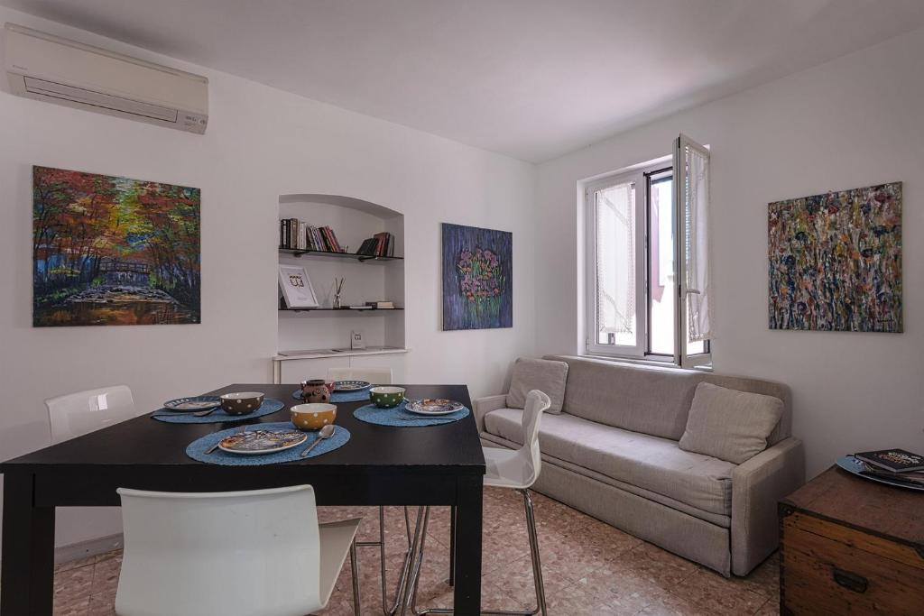 Casa Artè by Wonderful Italy في سانتا مارغريتا ليغور: غرفة معيشة مع طاولة وأريكة