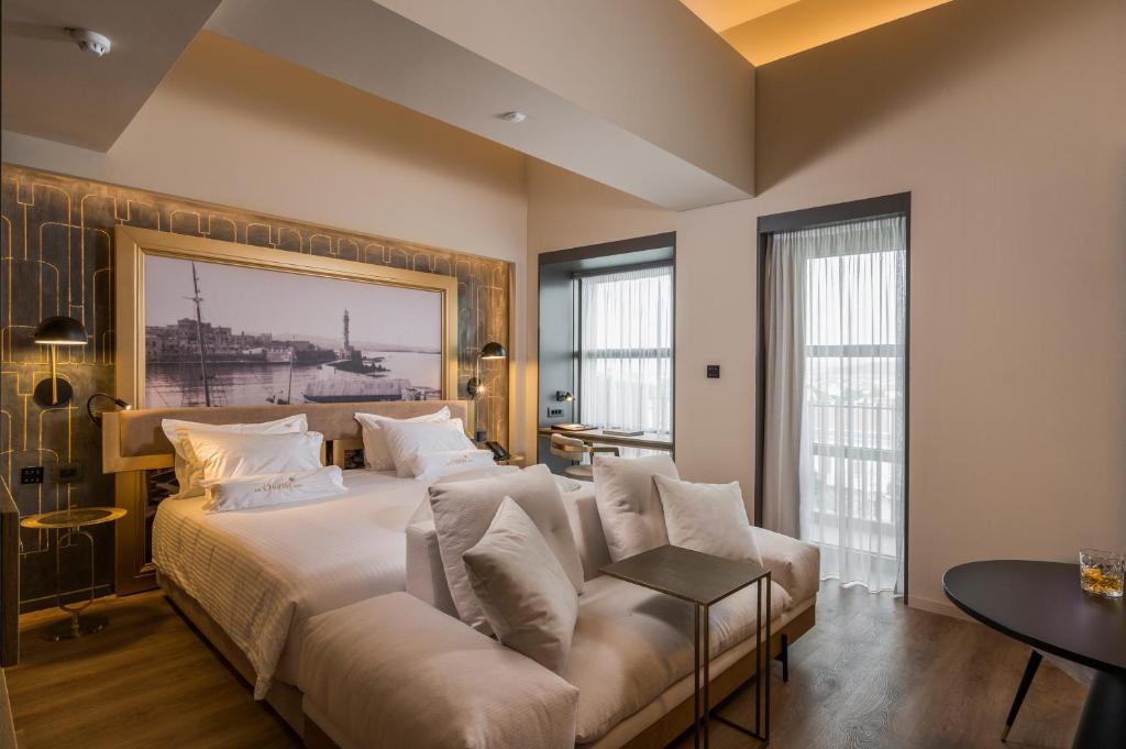 una camera con un grande letto e un divano di The Chania Hotel a Chania