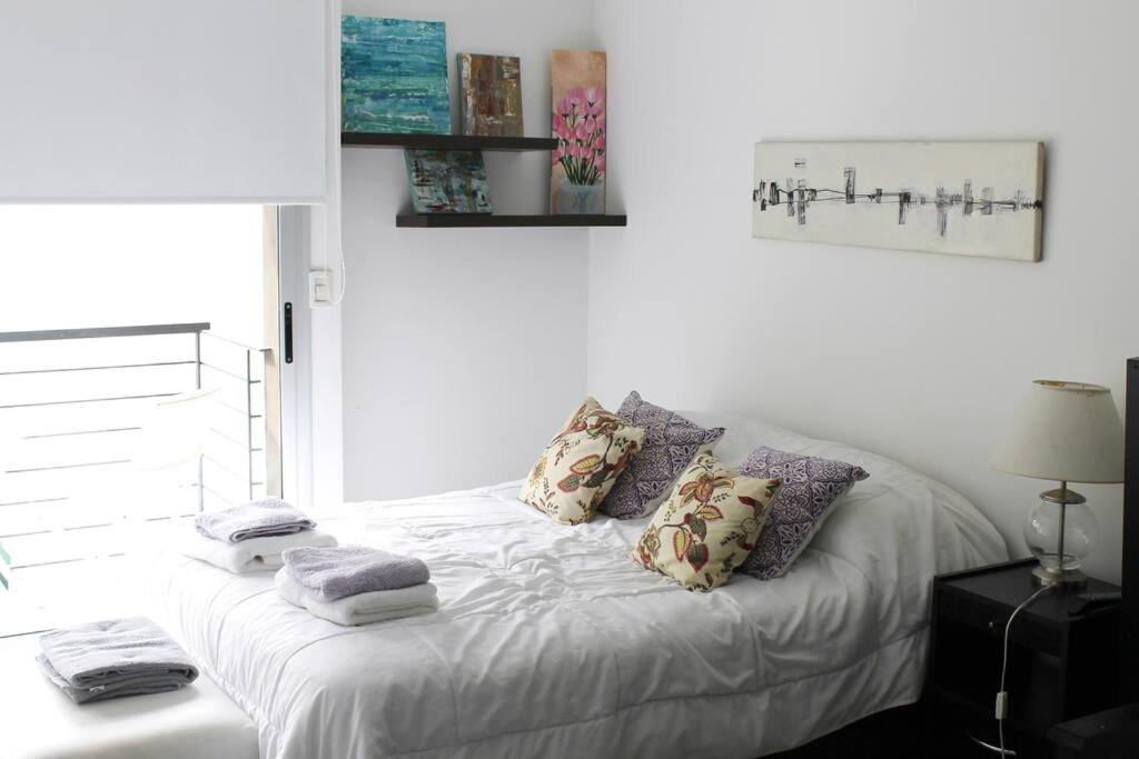 a white bed with pillows and towels on it at STUDIO Fitz Roy - By HART in Buenos Aires