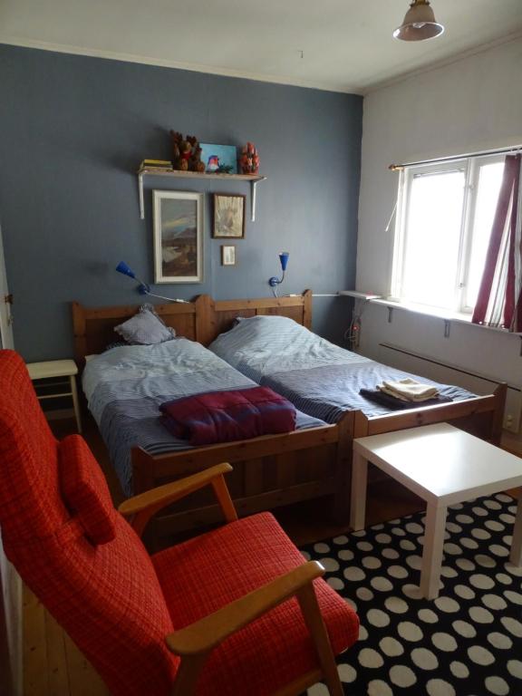 a bedroom with a bed and a chair and a table at Guesthouse Simolle in Hammarstrand