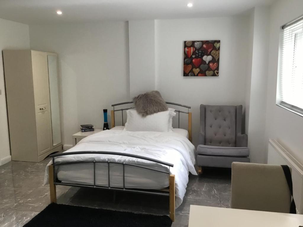 a bedroom with a bed and a chair at Furze Cottages in Buckinghamshire