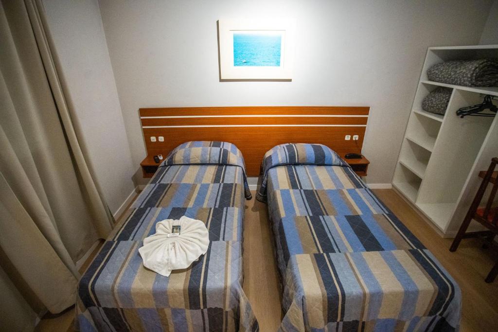 a pair of beds in a small room at Hotel Raul's in Gaspar