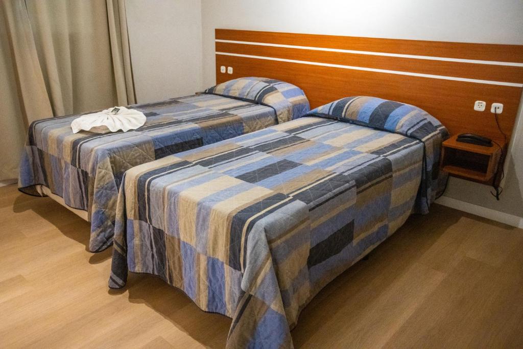 two beds sitting next to each other in a room at Hotel Raul's in Gaspar