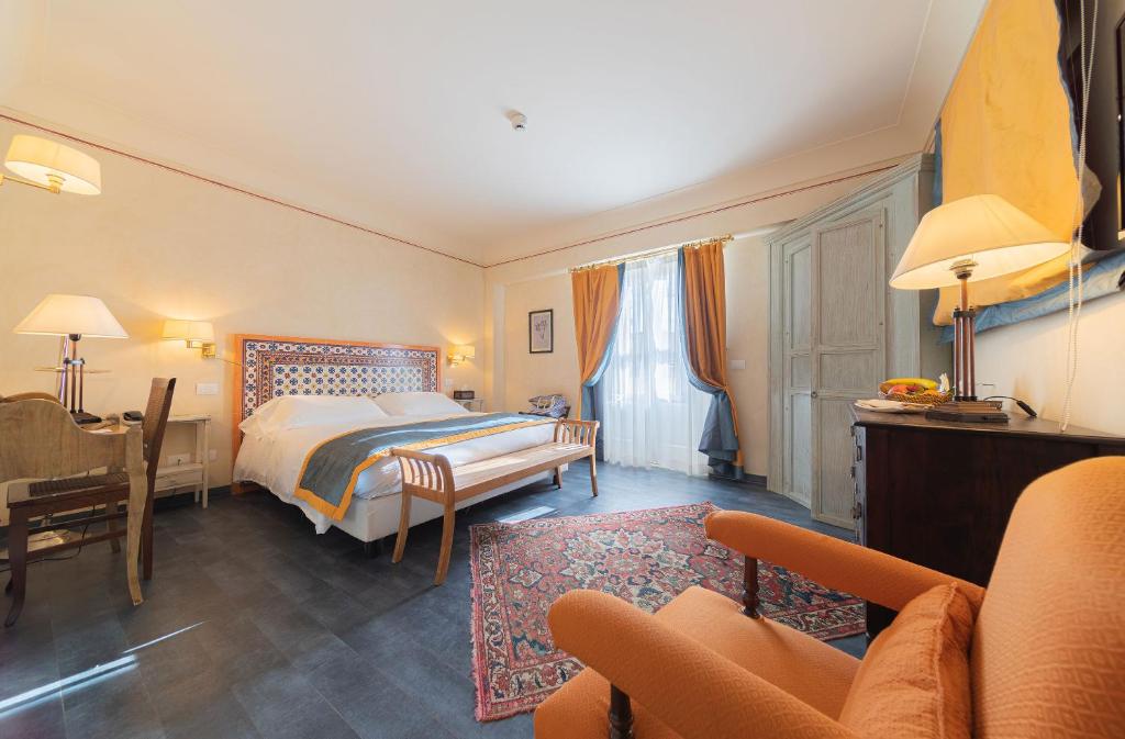 1 dormitorio con cama, escritorio y sofá en Algilà Ortigia Charme Hotel en Siracusa
