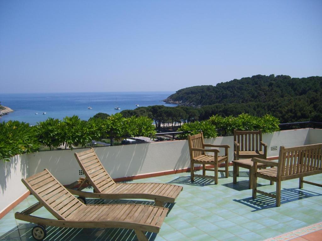 een groep stoelen en tafels op een balkon bij Hotel Galli - Wellness & Spa in Fetovaia