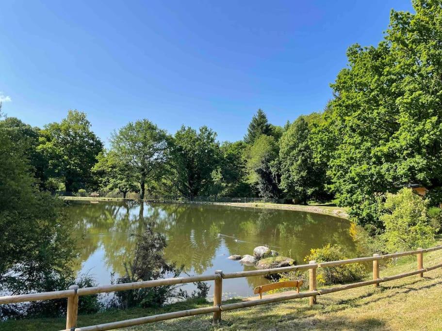 un estanque con un banco junto a una valla en Domaine de 6 hectares avec 2 étangs que pour vous, en Nontron