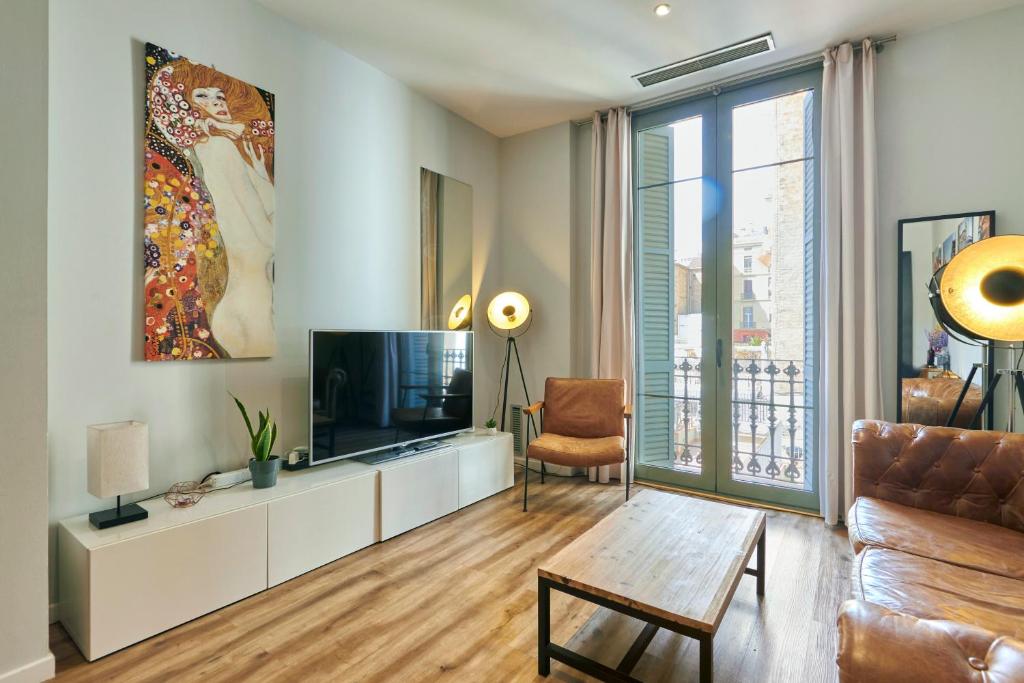 uma sala de estar com uma televisão e um sofá em Quiet Luxury 2-bed apartment for couples & families em Barcelona