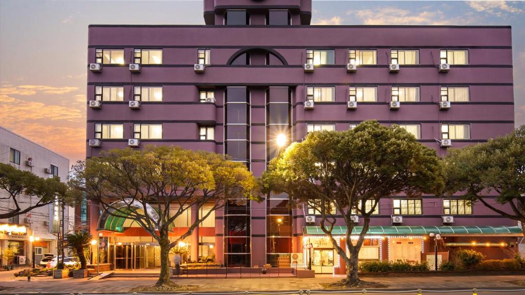 a purple building with trees in front of it at Hiker Hotel in Jeju