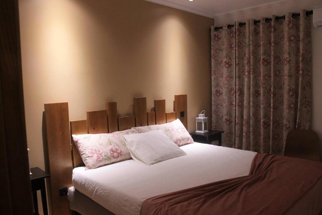 a bedroom with a large bed with a wooden headboard at Casa do Centro in Pessegueiro