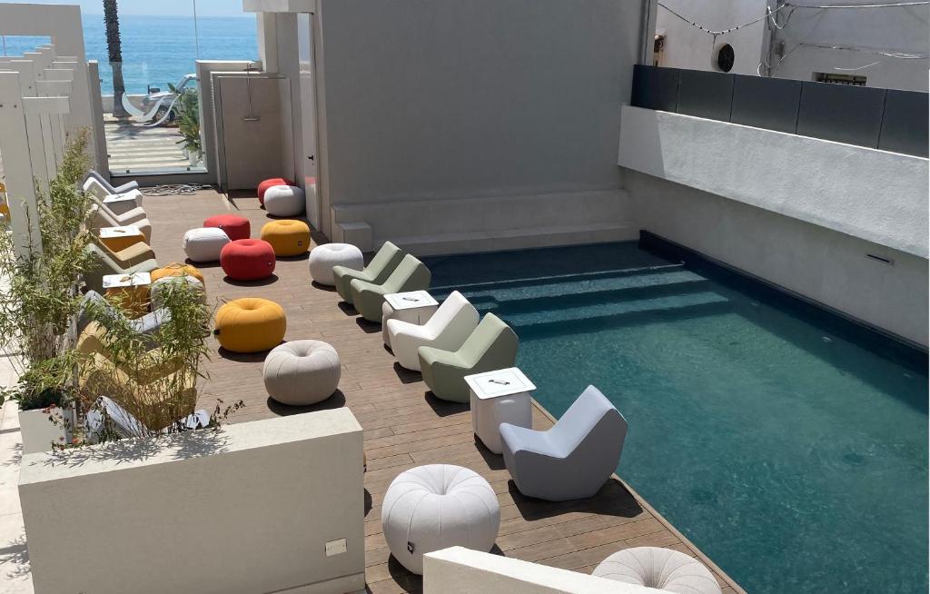 a swimming pool with chairs and a swimming pool at Albatros Beach Hotel in Letojanni