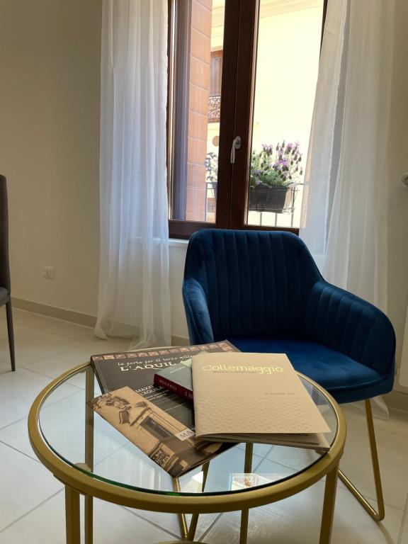un soggiorno con sedia blu e tavolo in vetro di B & B Piazza Angioina a L'Aquila
