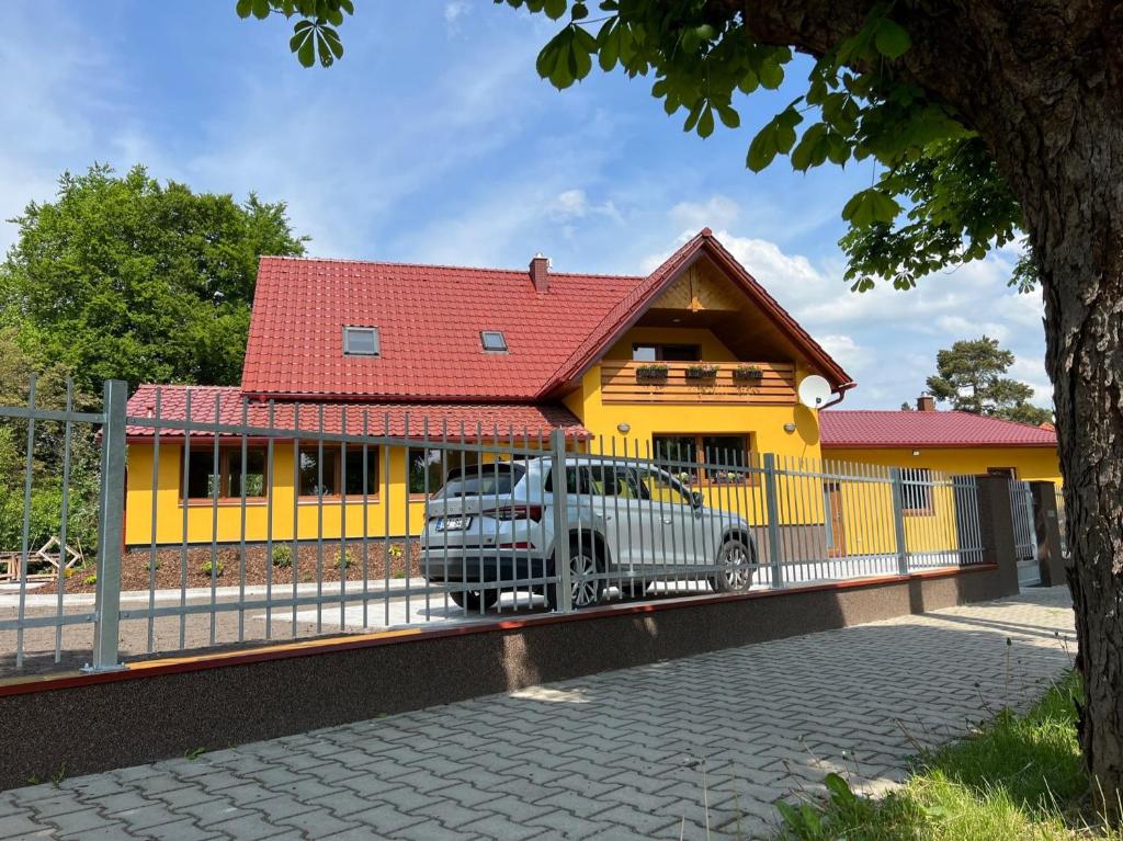 a car parked in front of a yellow house at U Marků in Staré Splavy