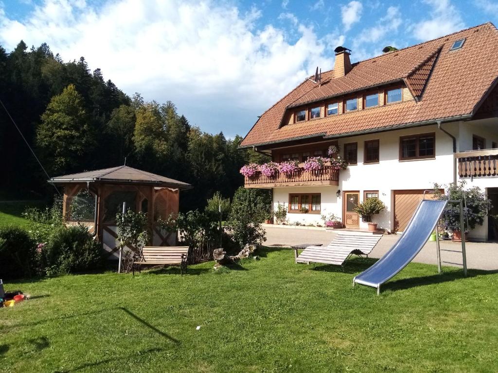 a house with a slide in the yard at Schreinerhäusle in Himmelreich