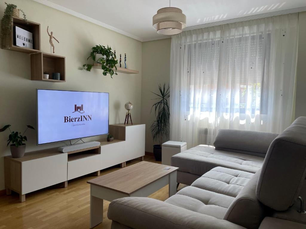 sala de estar con sofá y TV de pantalla plana en BierzINN apartamento, en Ponferrada