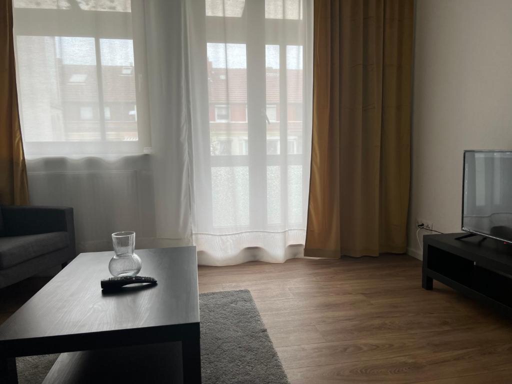 ein Wohnzimmer mit einem TV und einem Tisch mit einem Glas in der Unterkunft Holiday Home in Bremen