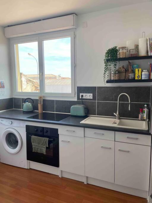 une cuisine avec un évier et une machine à laver dans l'établissement Proche des plages - Beau T2 climatisé, à Narbonne