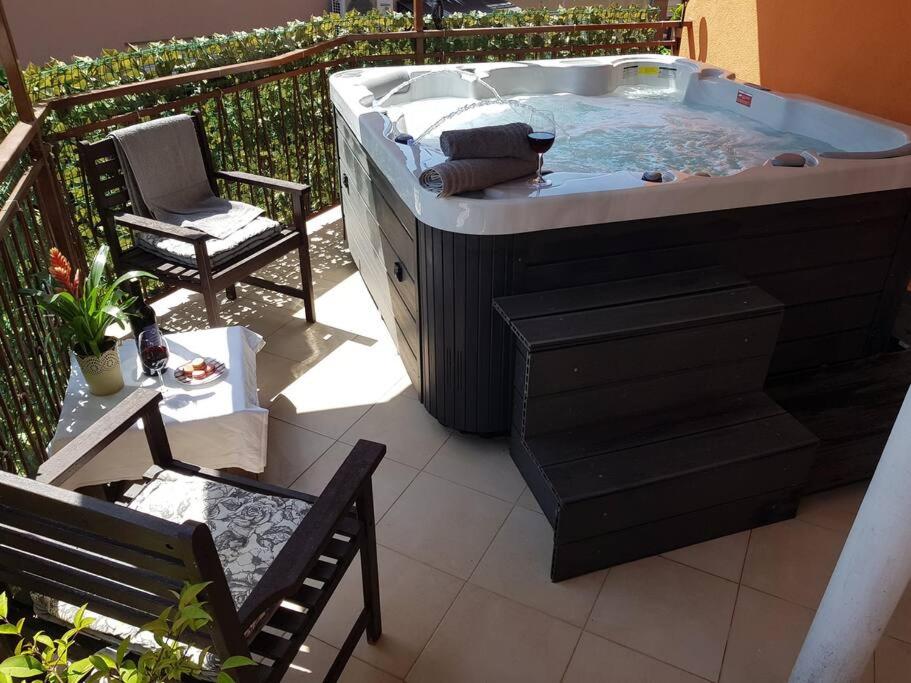 a hot tub on a patio with a chair and a table at Mediterranean ocean view 4star appartment in Villa in Rijeka