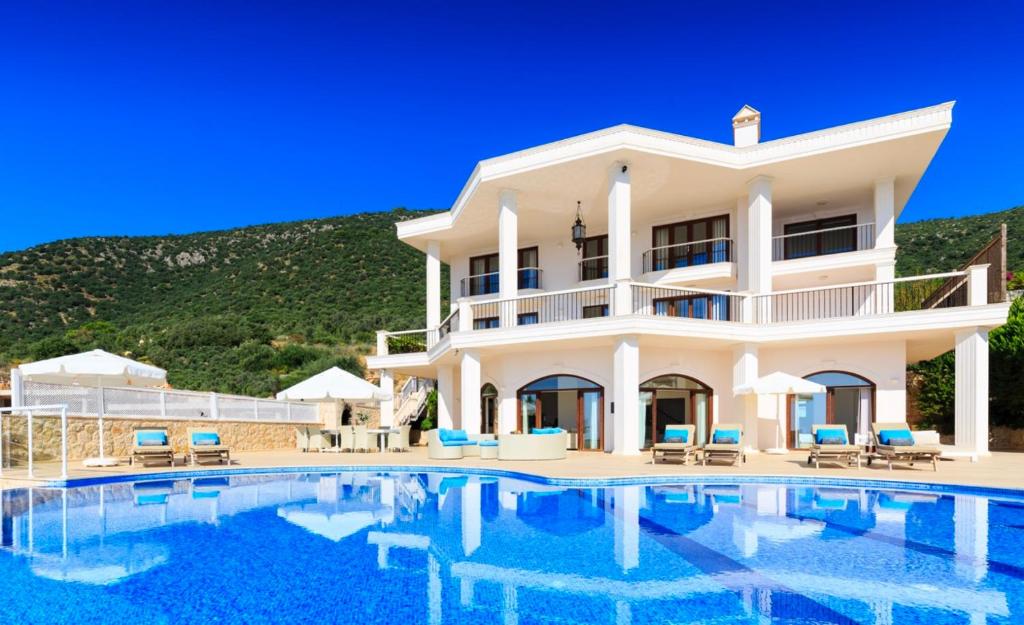 a villa with a swimming pool in front of a house at The Korsan Kuzey in Kas