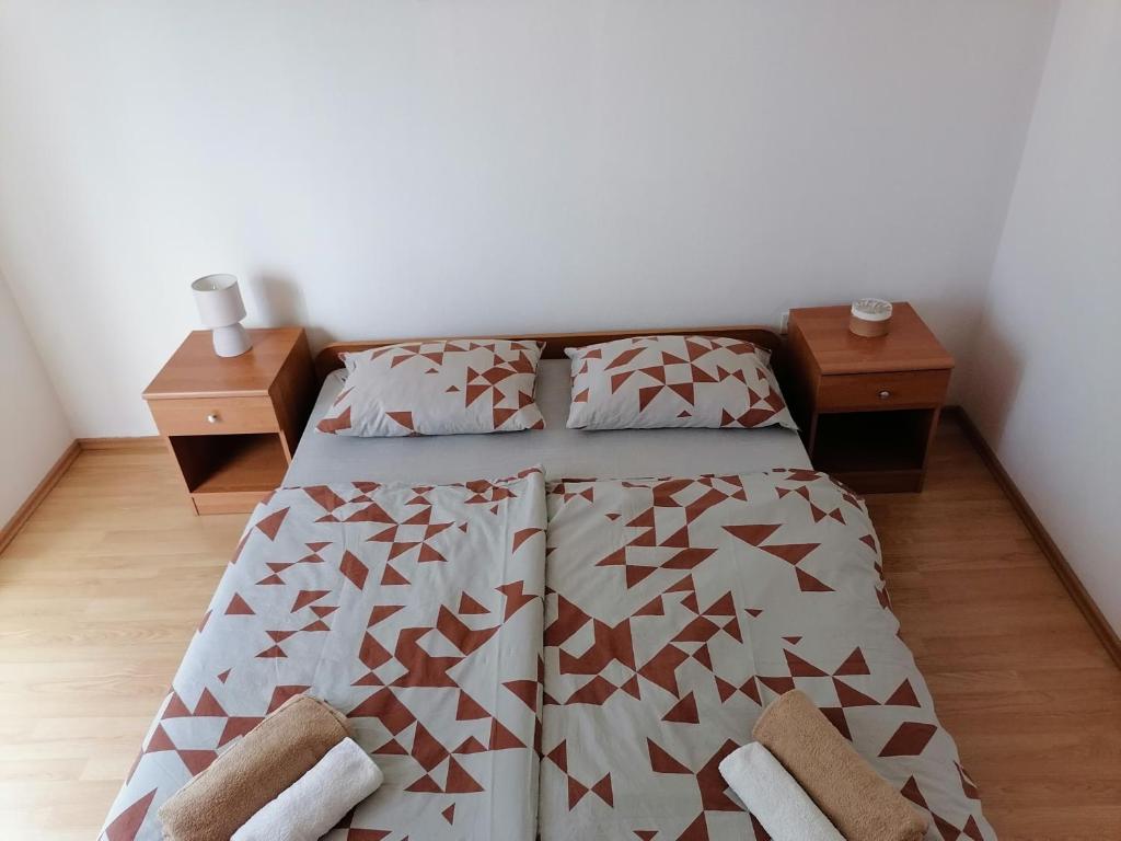 ein Schlafzimmer mit einem Bett und zwei Nachttischen in der Unterkunft Apartments Zdenka in Grebaštica