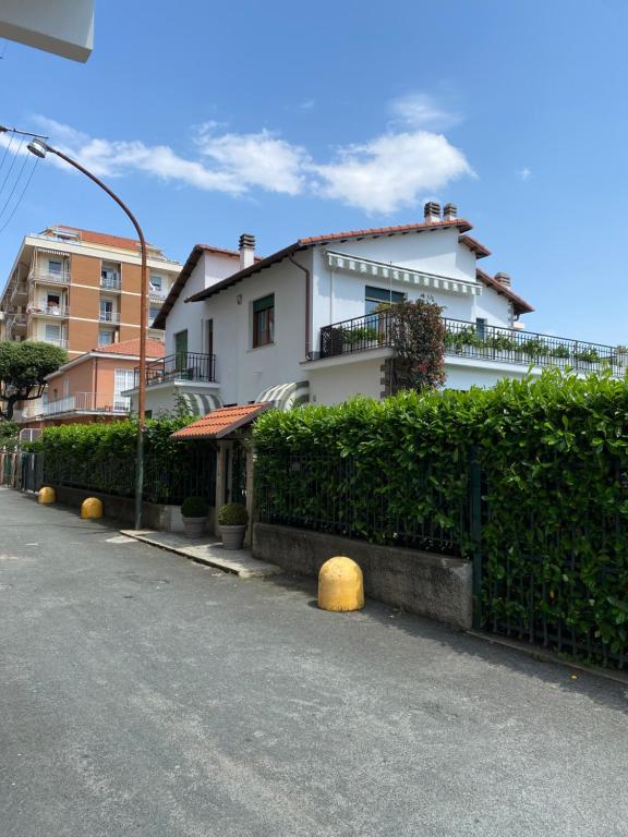 ein weißes Haus mit Hecke vor einer Straße in der Unterkunft Da Gianni al Mare in Lavagna