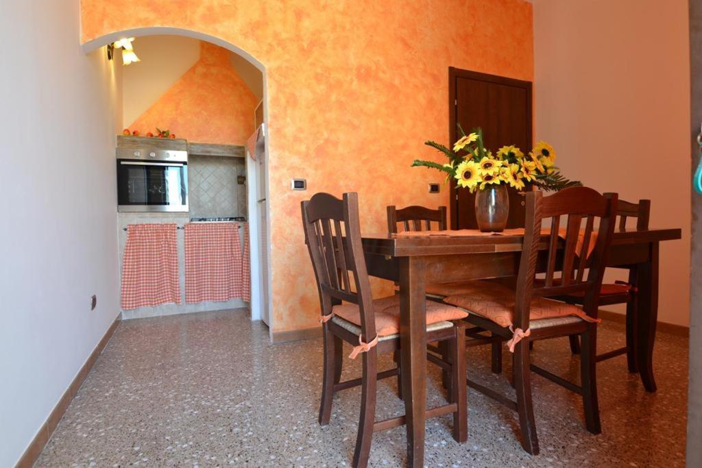 einen Esstisch mit Stühlen und eine Vase aus Blumen in der Unterkunft Casa Salento Maria in Marina di Mancaversa