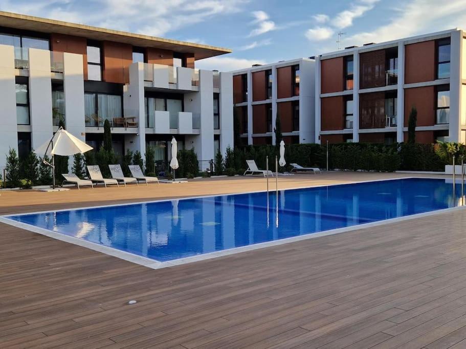 a hotel with a swimming pool in front of a building at Espectacular piso nuevo con piscina in Platja  d'Aro