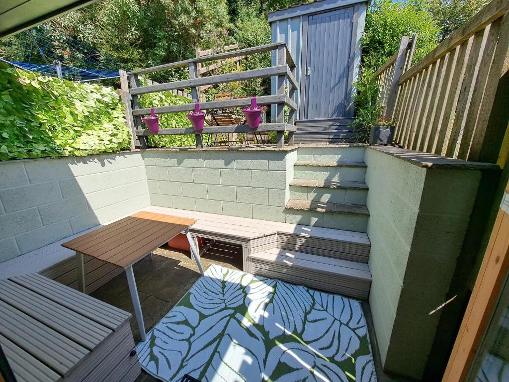 d'une terrasse avec une table, un banc et des escaliers. dans l'établissement Bwthyn Gweilch, à Machynlleth