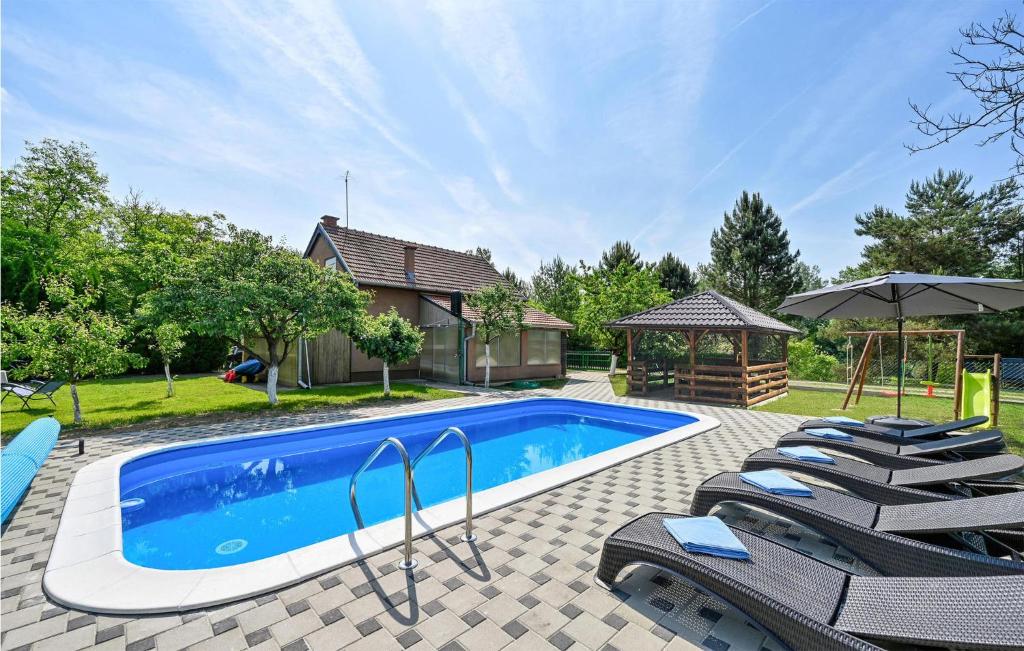 a swimming pool with chairs and a gazebo at Stunning Home In Molve Grede With Heated Swimming Pool in Medvedička