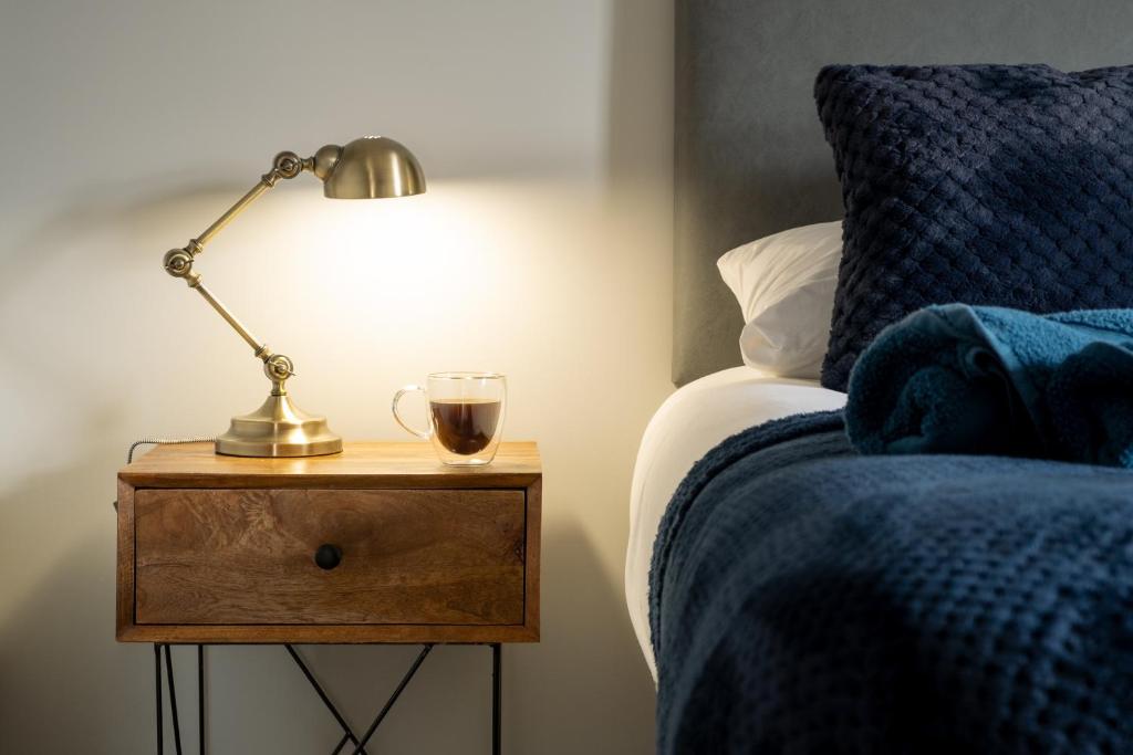 a lamp on a night stand next to a bed at Exclusive House with Canadian Hot Tub in Great Yarmouth